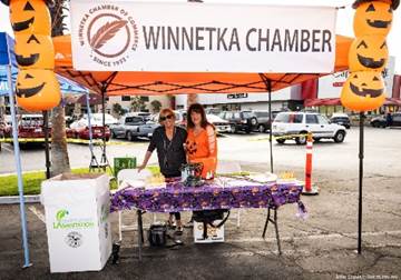 Two women standing under an orange tent

Description automatically generated